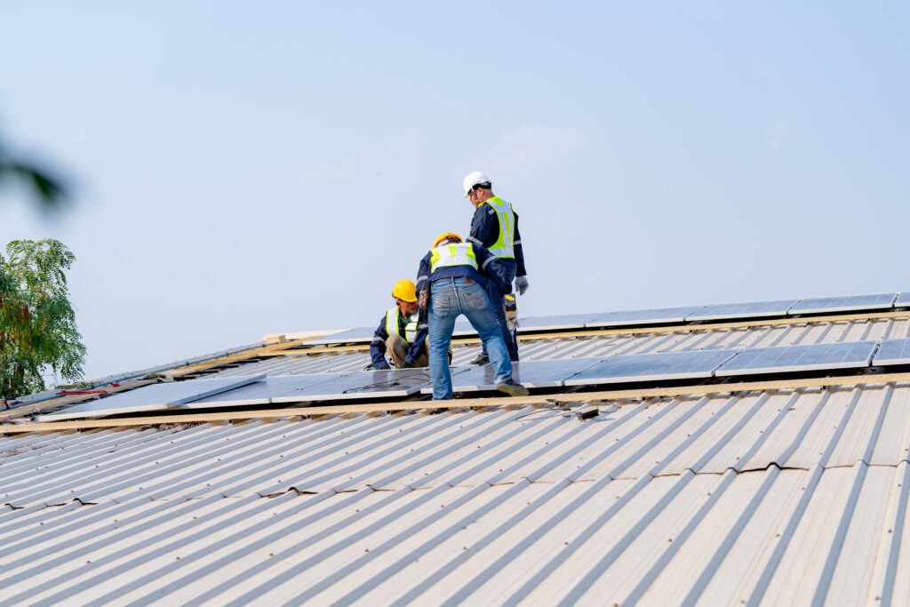 Workers installing solar panels, for efficient energy on rooftop